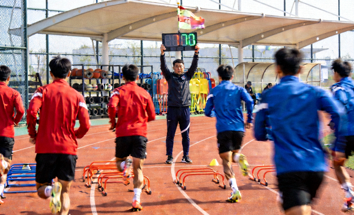 球队在训练基地进行体能训练，球员分组进行短距离冲刺